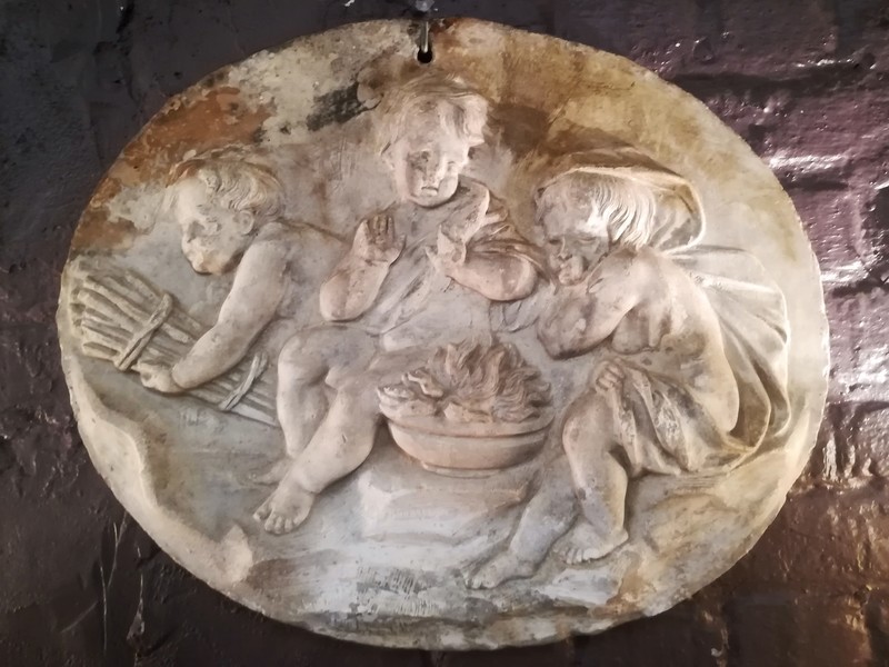 Plasterboard with putti decoration around a brazier